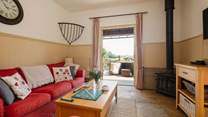 The comfortable living space with wood-burning stove and French doors opening onto the private decking area.