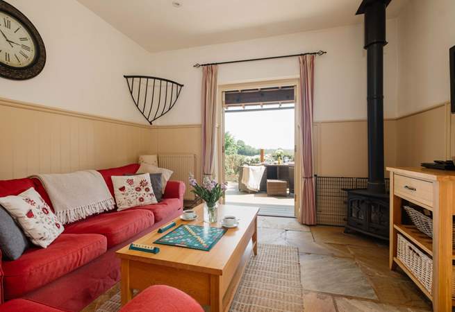 The comfortable living space with wood-burning stove and French doors opening onto the private decking area.