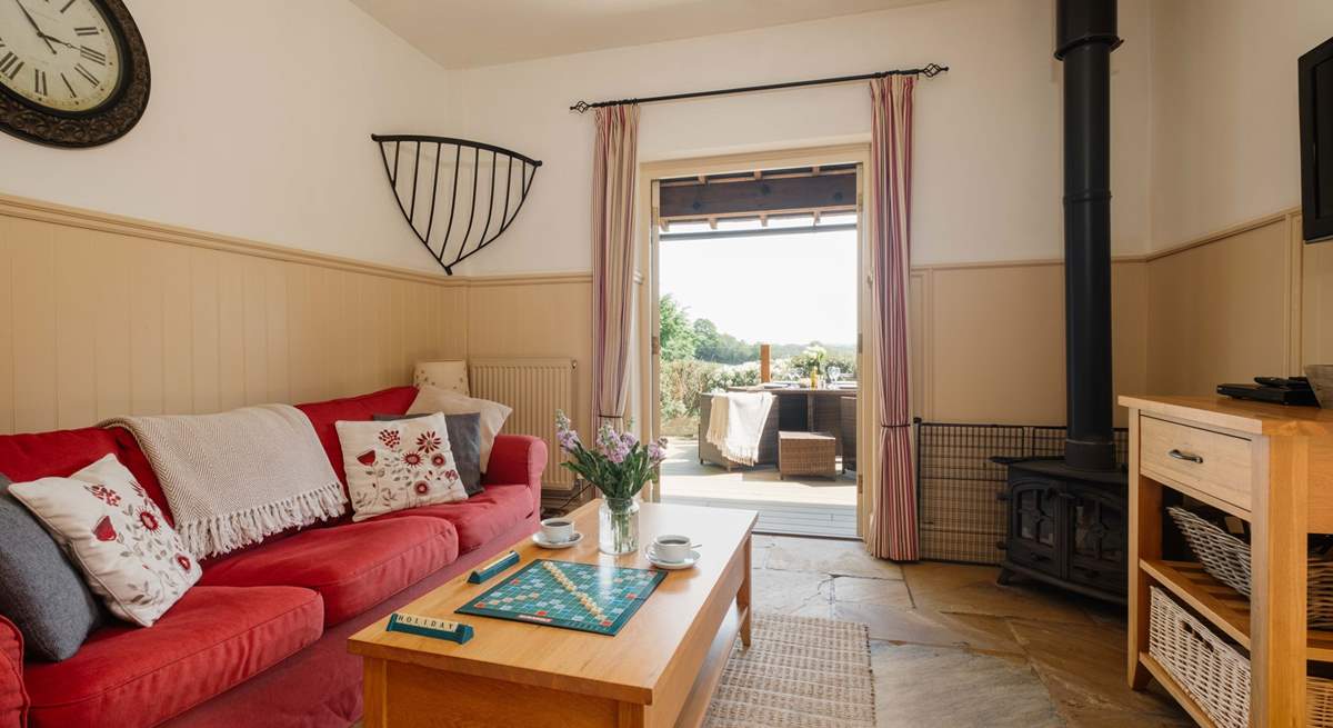 The comfortable living space with wood-burning stove and French doors opening onto the private decking area.