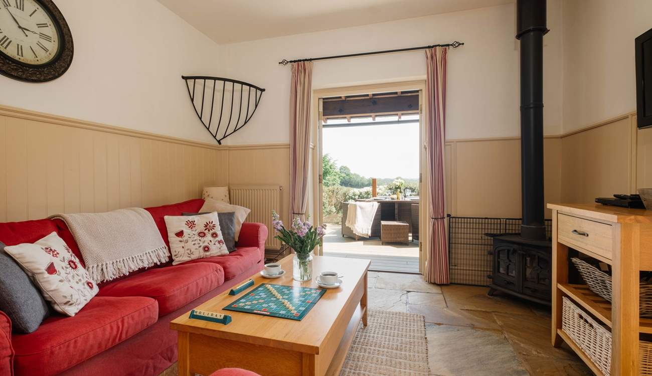 The comfortable living space with wood-burning stove and French doors opening onto the private decking area.