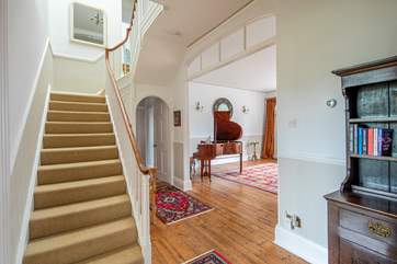 The lovely hallway with wooden floors and original staircase leading up to the bedrooms.