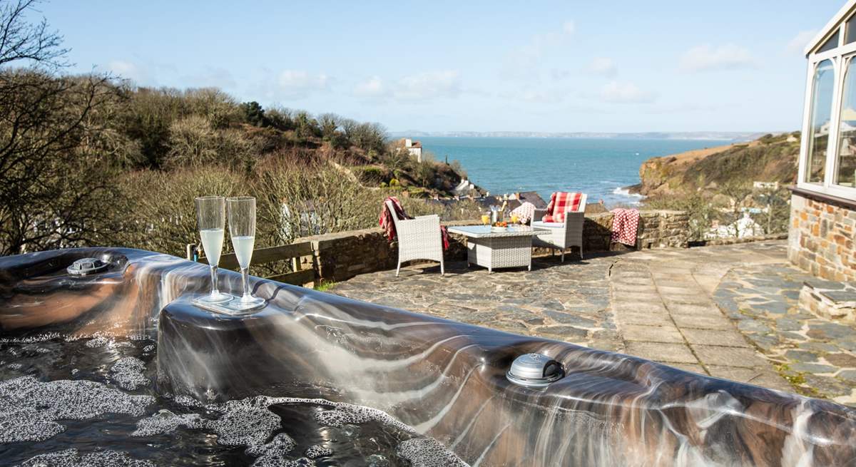 Relax in the idyllic, spacious hot tub taking in the captivating sea views. 