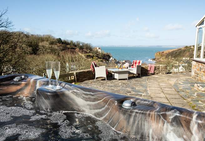 Relax in the idyllic, spacious hot tub taking in the captivating sea views. 