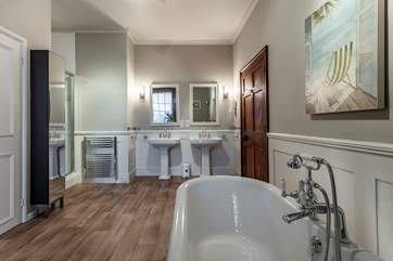 The bathroom on the first floor with bath, separate shower and double wash-basins.
