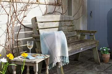 A glass of wine wine under the dappled shade of the grape vine overlooking the garden.