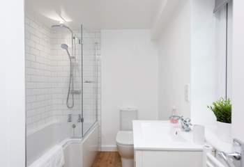 The bathroom is on the ground floor and has a waterfall shower over the bath.