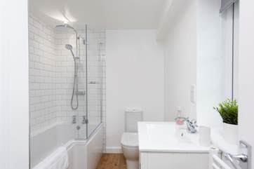 The bathroom is on the ground floor and has a waterfall shower over the bath.