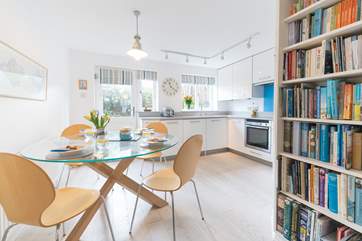 The open plan living-room with kitchen and dining areas leads outside to the enclosed patio.