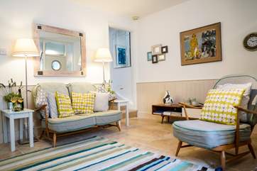 The sitting-room offers flexible seating with comfortable chairs and wonderful textiles from Bali and fields afar.