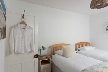 A wooden step leads up from the small landing into the pretty twin bedroom.