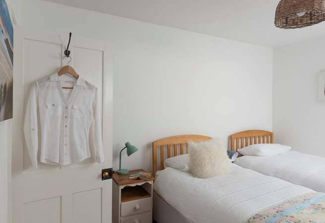 A wooden step leads up from the small landing into the pretty twin bedroom. 