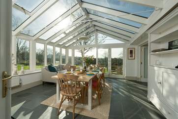 The fabulous garden-room makes a lovely dining-room. The double doors to the right lead into the main sitting-room.