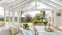 The fabulous garden-room makes a lovely dining spot. The double doors to the right lead into the main sitting-room.
