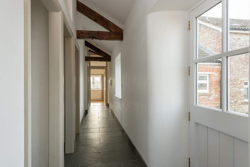 A wide corridor leads to the bedrooms. You can glimpse Wreath Farmhouse (4445) through the front door of the cottage. 