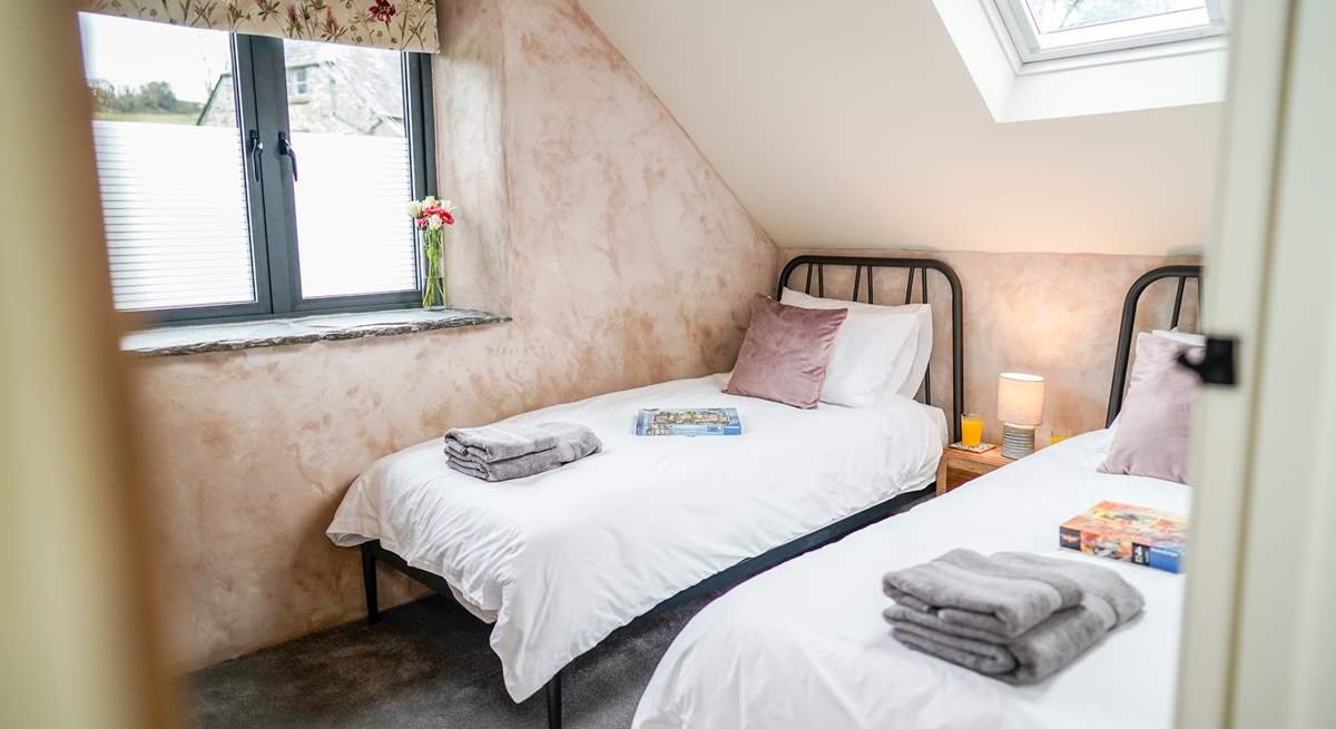 The light twin room has a wall-mounted TV. You will see the bottom half of the window is obscured for privacy, as this room looks out towards the owners' farmhouse.