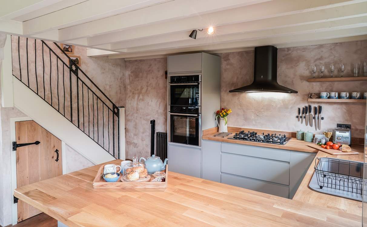 The kitchen also has a handy breakfast-bar with two stools that add to this wonderful open plan space.