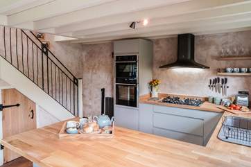 The kitchen also has a handy breakfast-bar with two stools that add to this wonderful open plan space.
