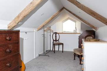 On the second floor there is a lovely snug area, if you fancy escaping for some quiet time. From the window you can catch glimpses of the sea. As the stairs are steep and eaves are low we recommend this area is not for young children.