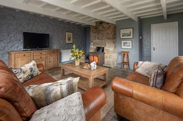 What a fabulous sitting-room with a huge glowing wood-burning stove.