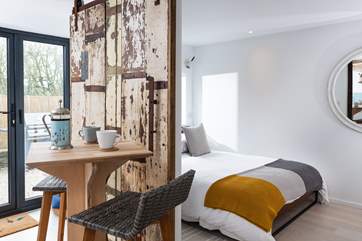 The bedroom is separated from the kitchen and dining areas by a sliding door made from original Georgian timbers.