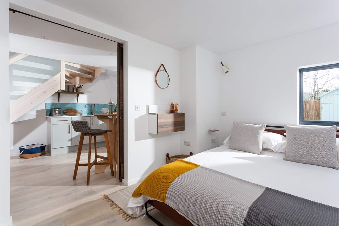 The view from the bedroom to the kitchen and dining area. A sliding door cleverly separates these two spaces.