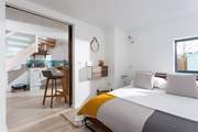 The view from the bedroom to the kitchen and dining area. A sliding door cleverly separates these two spaces.