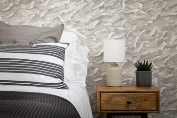The grey wallpaper helps create a very soothing and very restful room.