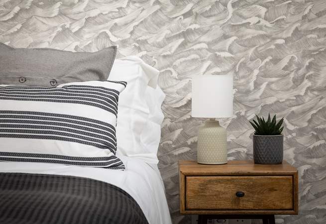 The grey wallpaper helps create a very soothing and very restful room.