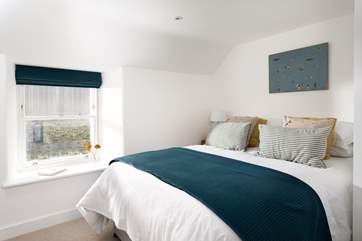 Bedroom number 2, in furnished in soft yellows and blues.