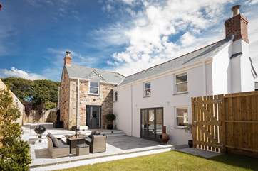 Welcome to Bower Cottage. Two steps lead down from the grassed area, and there are three small steps leading up to the top patio.