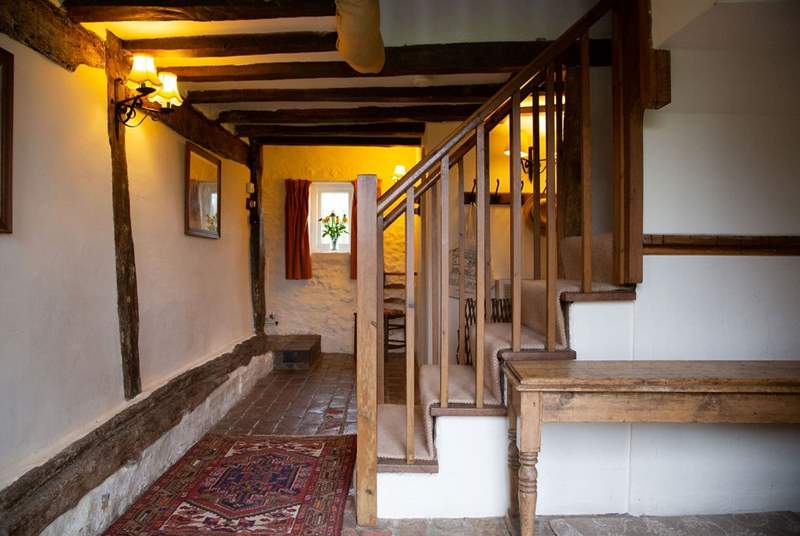 Entrance hall with brick floor and exposed beams.