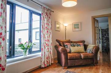 The sitting-room offers a family room with comfortable sofas and chairs, and views from every window.