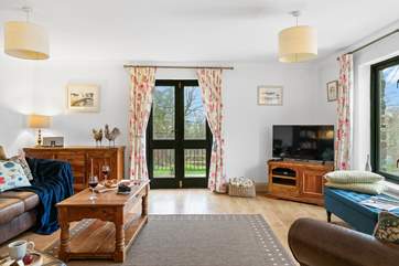 The comfortable sitting room has big windows to take in the surrounding views.