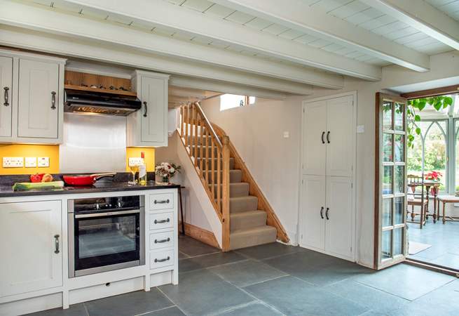 The kitchen opens to the conservatory and the stairs lead to the bedrooms and family bathroom. 