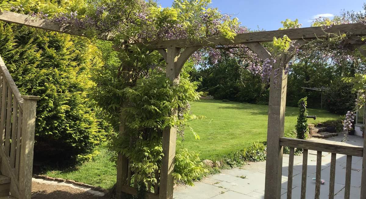 Scented wisteria in bloom surrounds the house.