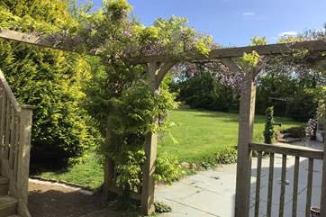 Scented wisteria in bloom surrounds the house.