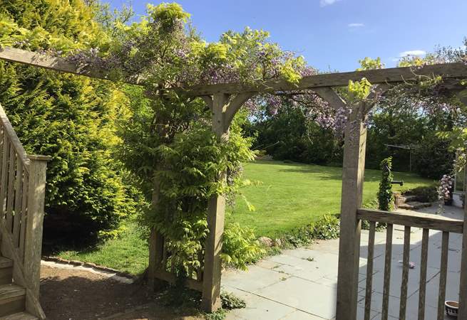 Scented wisteria in bloom surrounds the house.