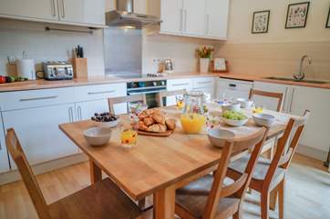 The kitchen offers a breakfast table with views out of the window to the enclosed courtyard.