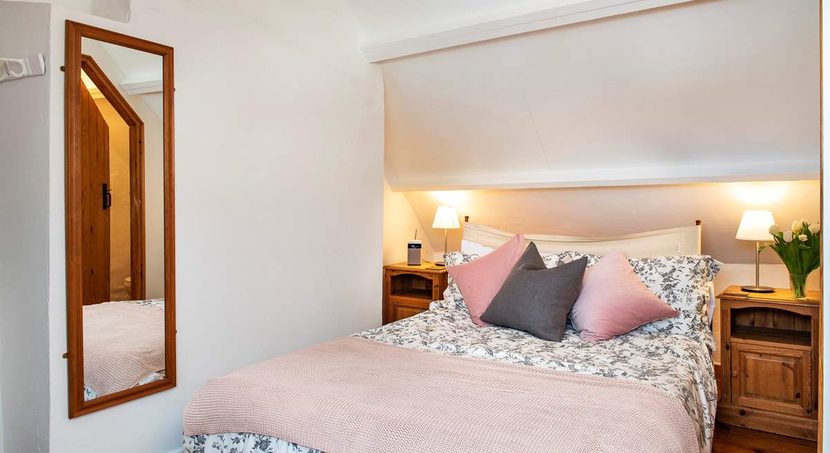 The bed in the second bedroom is adorned with lovely linens, cushions and throw.