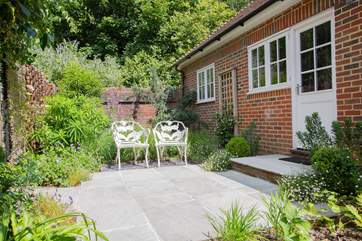 Step outside from the kitchen to an additional enclosed garden with seating for two.