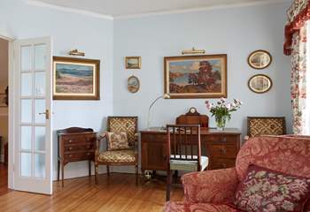 Exquisite paintings and a beautiful writing desk in the sitting room.