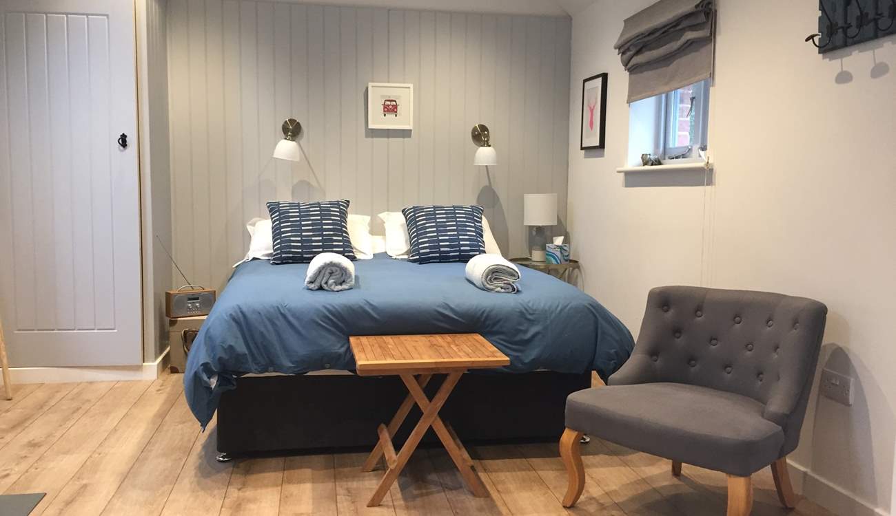 The open plan bedroom area with a comfortable large king-size double bed.