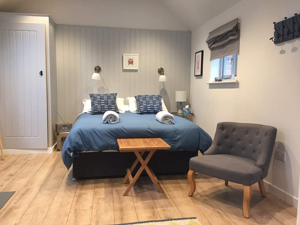 The open plan bedroom area with a comfortable large king-size double bed.