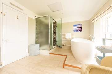 The family bathroom is incredibly spacious with a large shower cubicle and bath big enough for two sitting on the raised bathing platform at one end of the room.