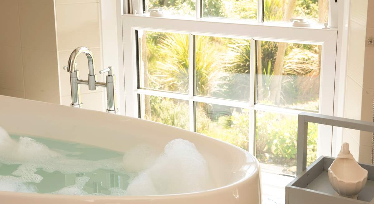 Enjoy the views of the gardens to the sea beyond from the comfort of the bath tub.