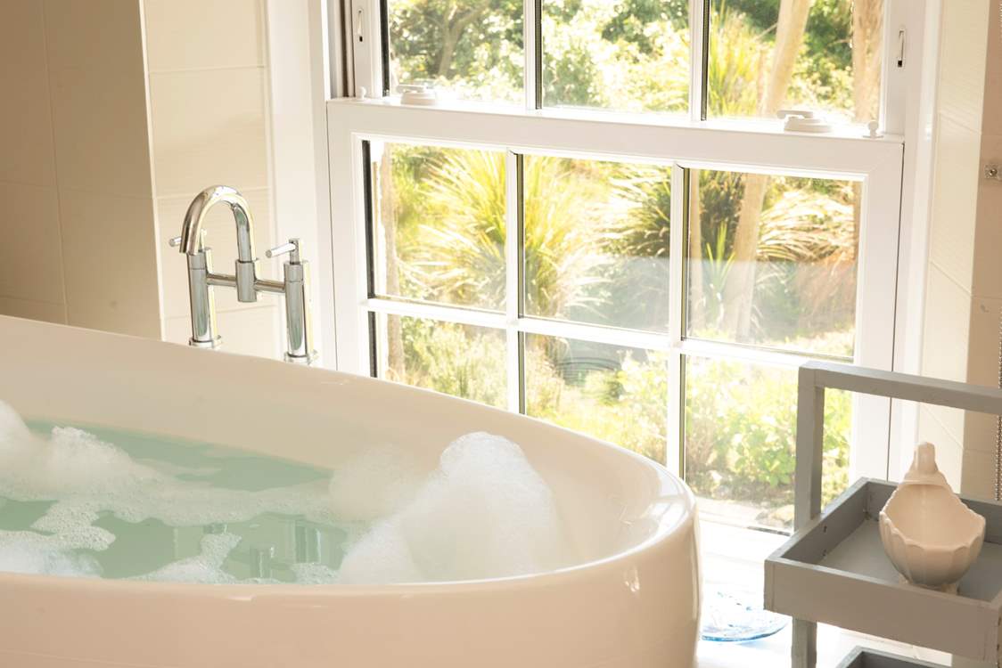 Enjoy the views of the gardens to the sea beyond from the comfort of the bath tub.