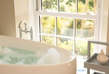 Enjoy the views of the gardens to the sea beyond from the comfort of the bath tub.