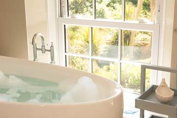 Enjoy the views of the gardens to the sea beyond from the comfort of the bath tub.