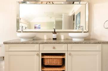 The large and stylish bathroom with double sinks at one end.