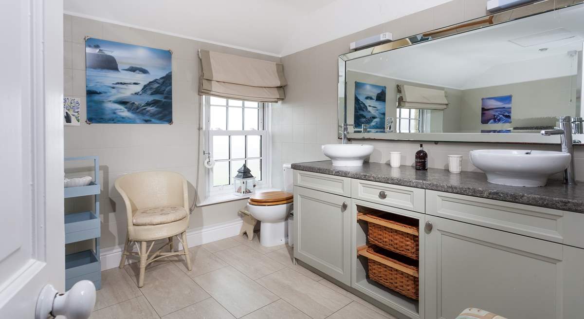 The large and stylish bathroom with double sinks at one end. 